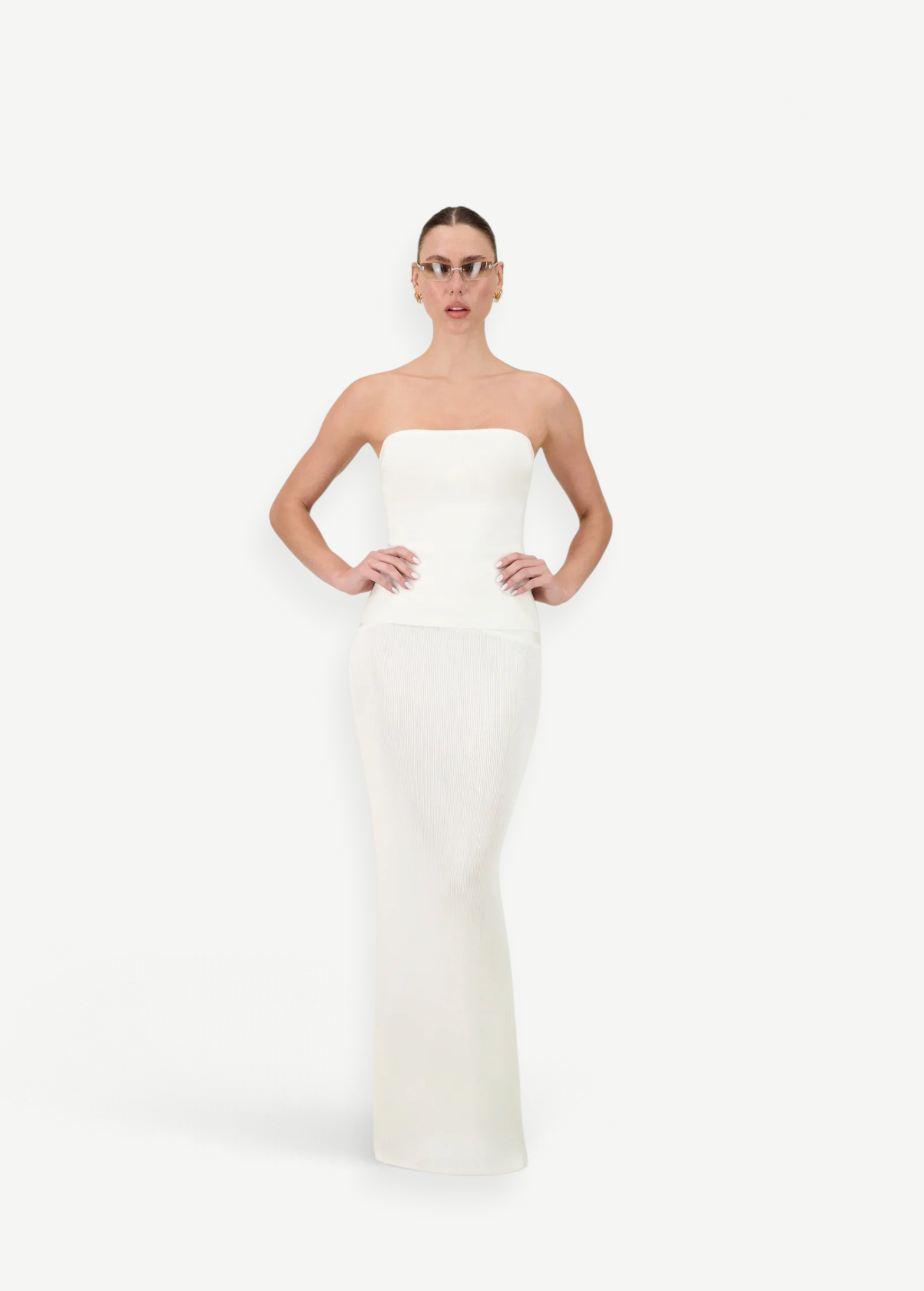 Model wearing a KABE SHOP INC white strapless maxi skirt with a matching fitted top in a studio setting.