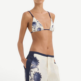 A person wearing a blue and white vintage print triangle bikini top and matching Phillipa Trouser wide-leg trousers with dark blue side panels.