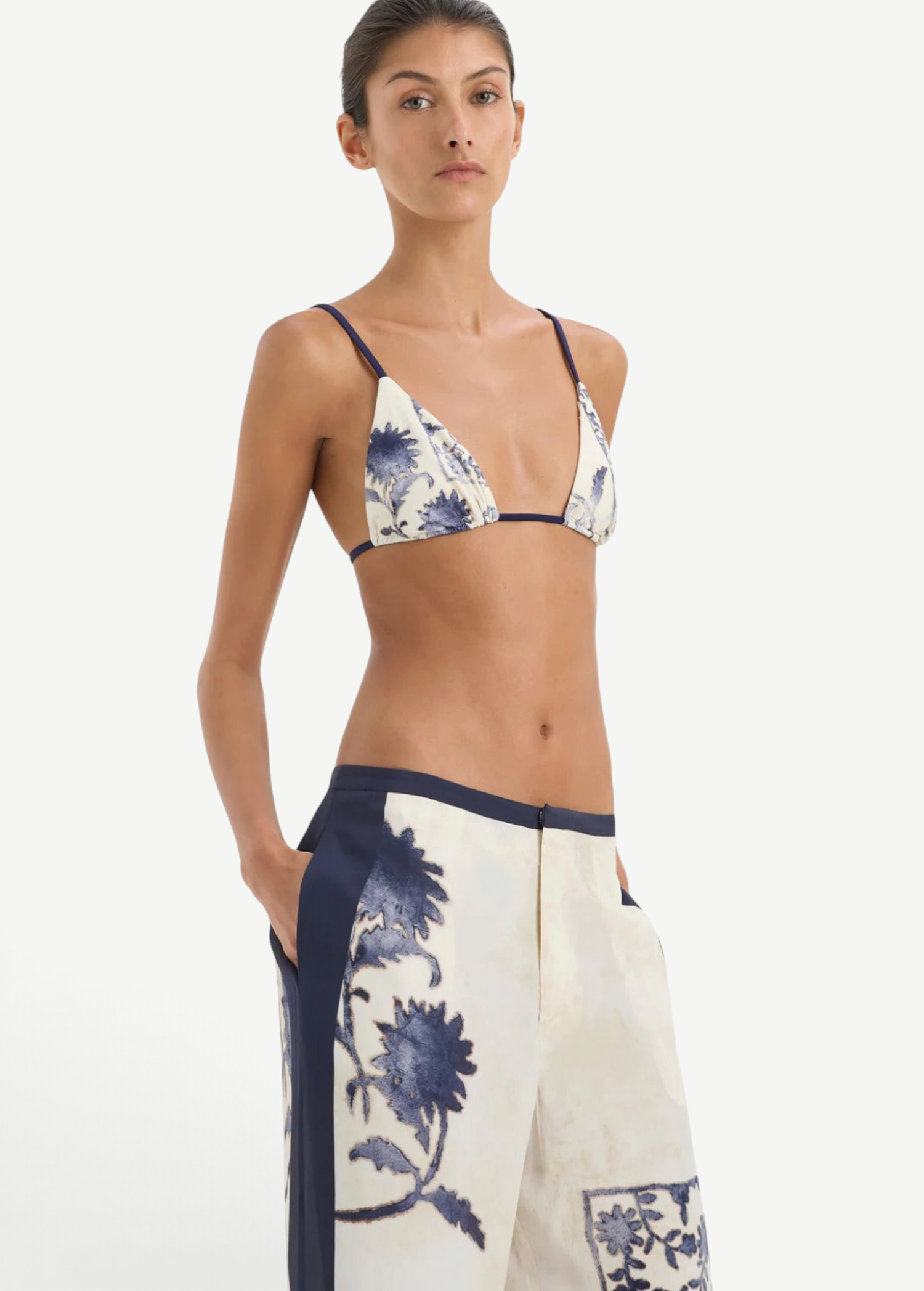 A person wearing a blue and white vintage print triangle bikini top and matching Phillipa Trouser wide-leg trousers with dark blue side panels.