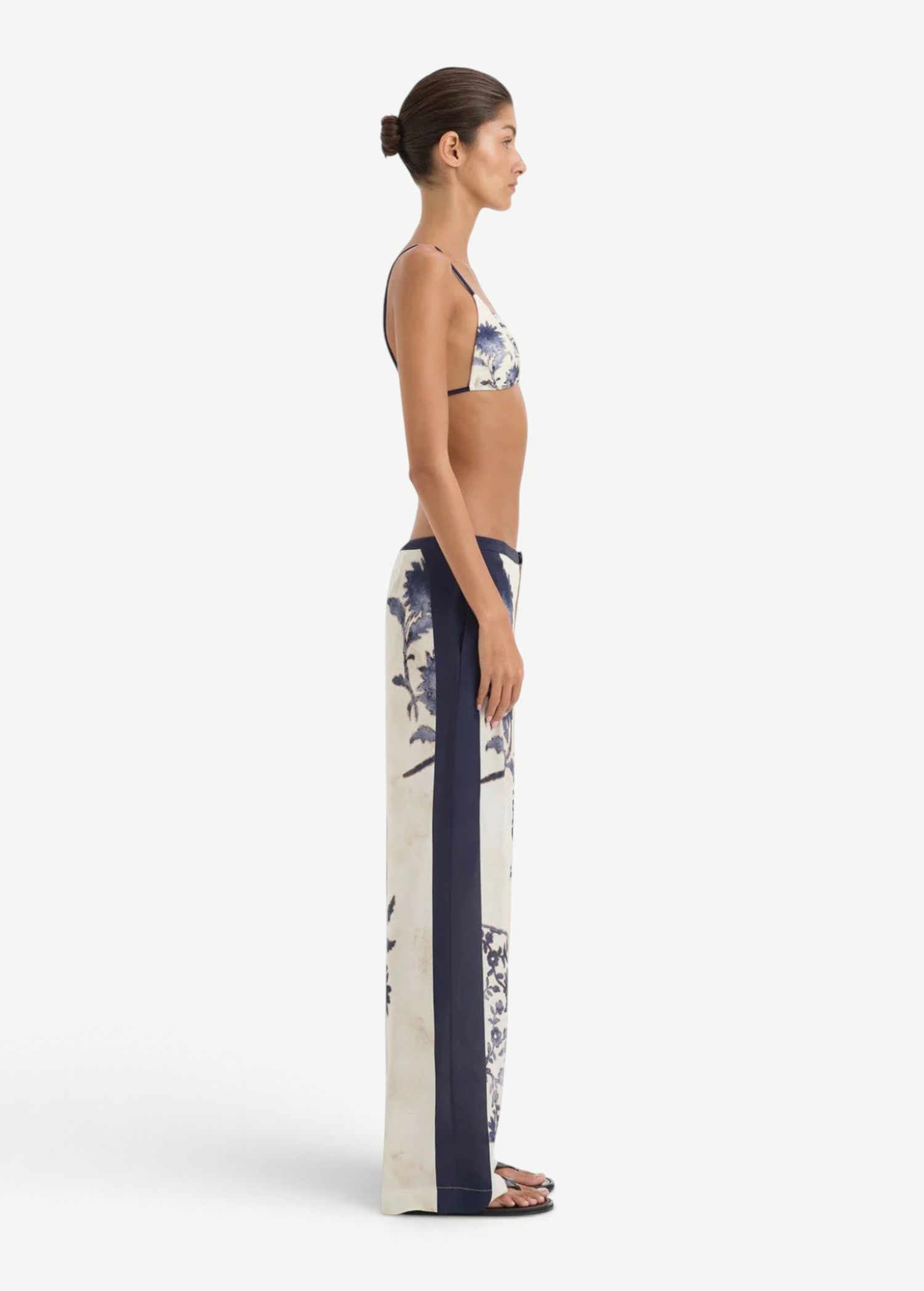 Side profile of a person wearing a bikini top and matching Phillipa Trouser in a vintage floral print with solid navy side panels.