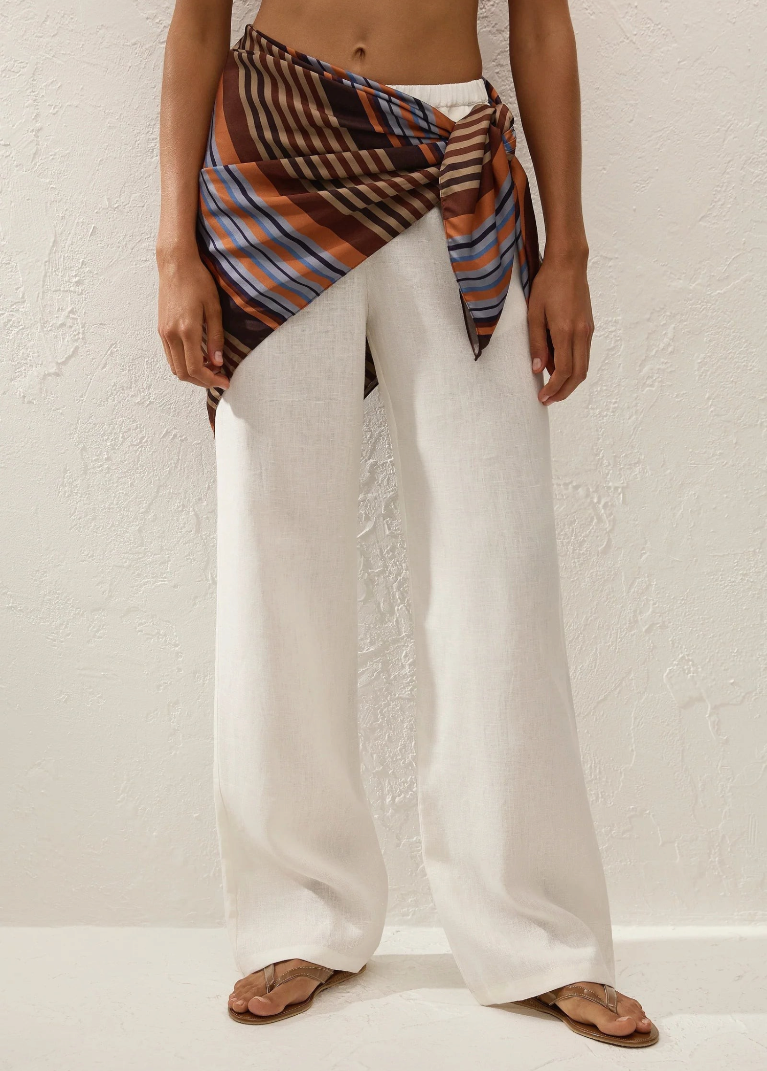 KABE SHOP INC Soleil waist scarf in striped satin tied over white linen trousers on a model