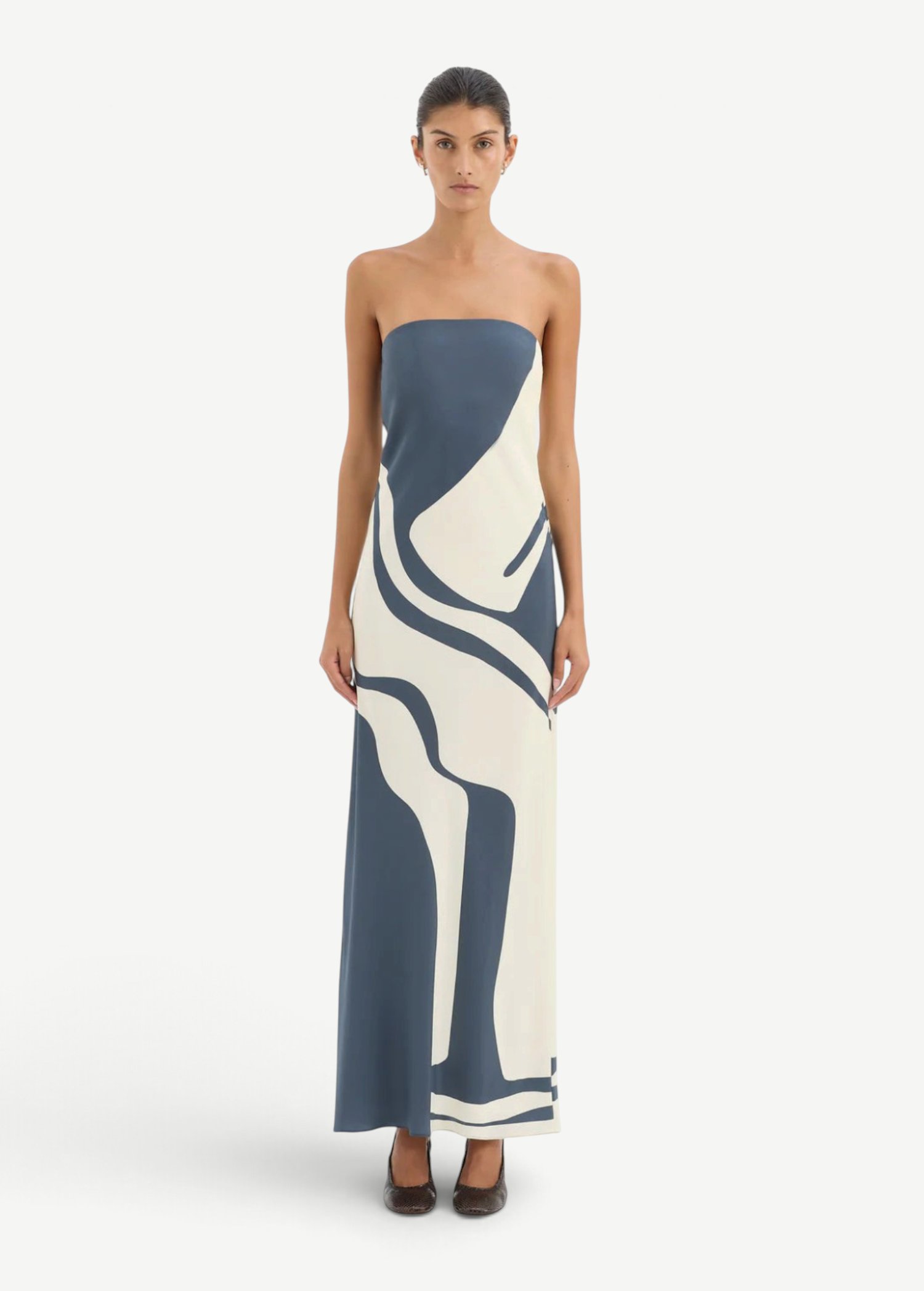 Model wearing KABE SHOP INC Lilou strapless silk midi dress with blue and cream abstract print and bias-cut fit.
