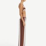 A person in profile wears a bikini top paired with matching Marais Trouser silk wide-leg trousers featuring an oversized stripe print.