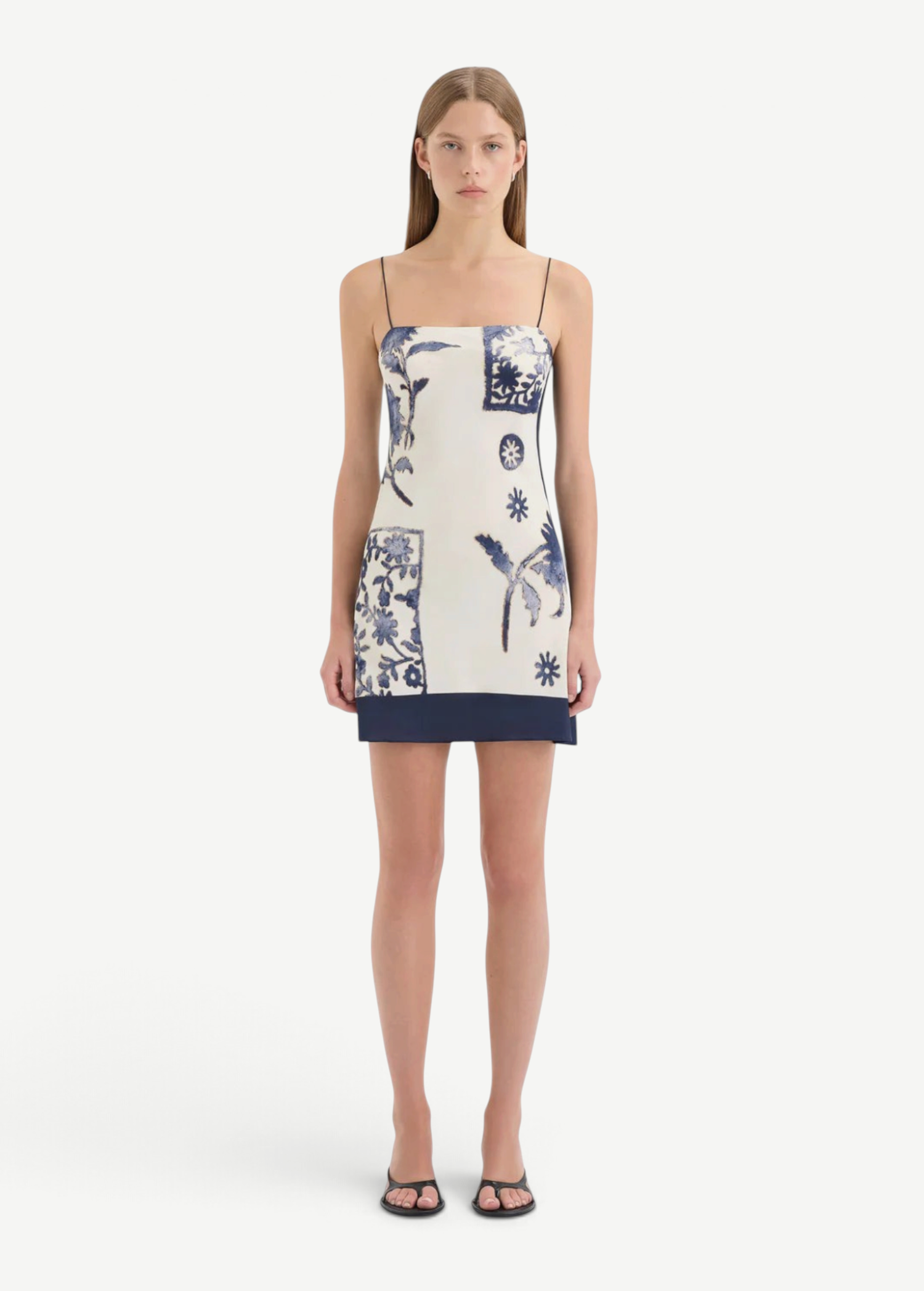 Model wearing KABE SHOP INC Phillipa silk-viscose mini slip dress with blue floral print and navy hem