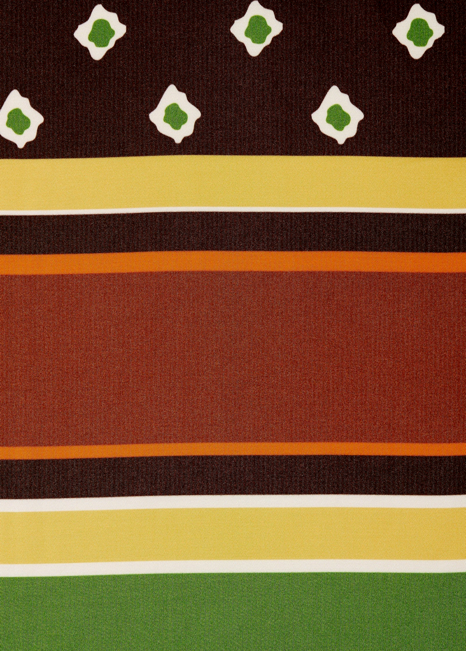 The Cora Shirt features a row of white-bordered green diamonds above horizontal stripes in yellow, dark brown, and orange, finished with a green band at the bottom.