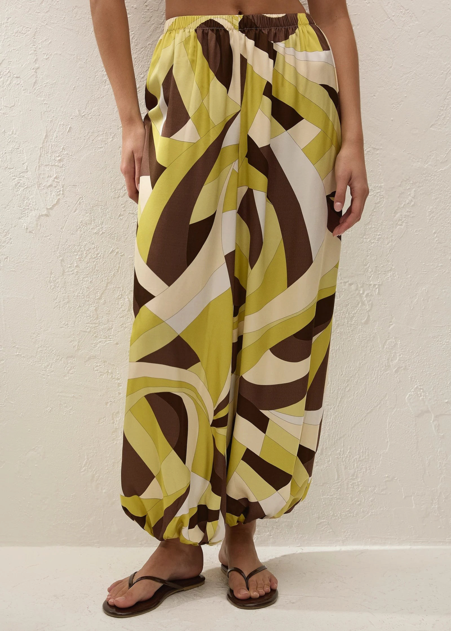 Kortez Balloon Pant featuring a high-waisted, relaxed-fit silhouette with a geometric pattern in olive, brown, and cream.