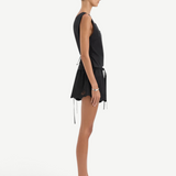 Side view of a person wearing a black sleeveless top and the matching Klara Mini Short featuring a tie waistband and floral cut-out embroidery along the scalloped hem.
