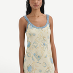 Model wearing KABE SHOP INC Cecile maxi slip dress in cream with blue vintage floral print and delicate ruffle trim
