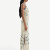 Model wearing KABE SHOP INC Cecile Ruffle Slip Dress in cream with blue floral print and delicate ruffled trim
