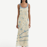 Model wearing KABE SHOP INC Cecile maxi slip dress in cream with blue vintage floral print and delicate ruffle trim.