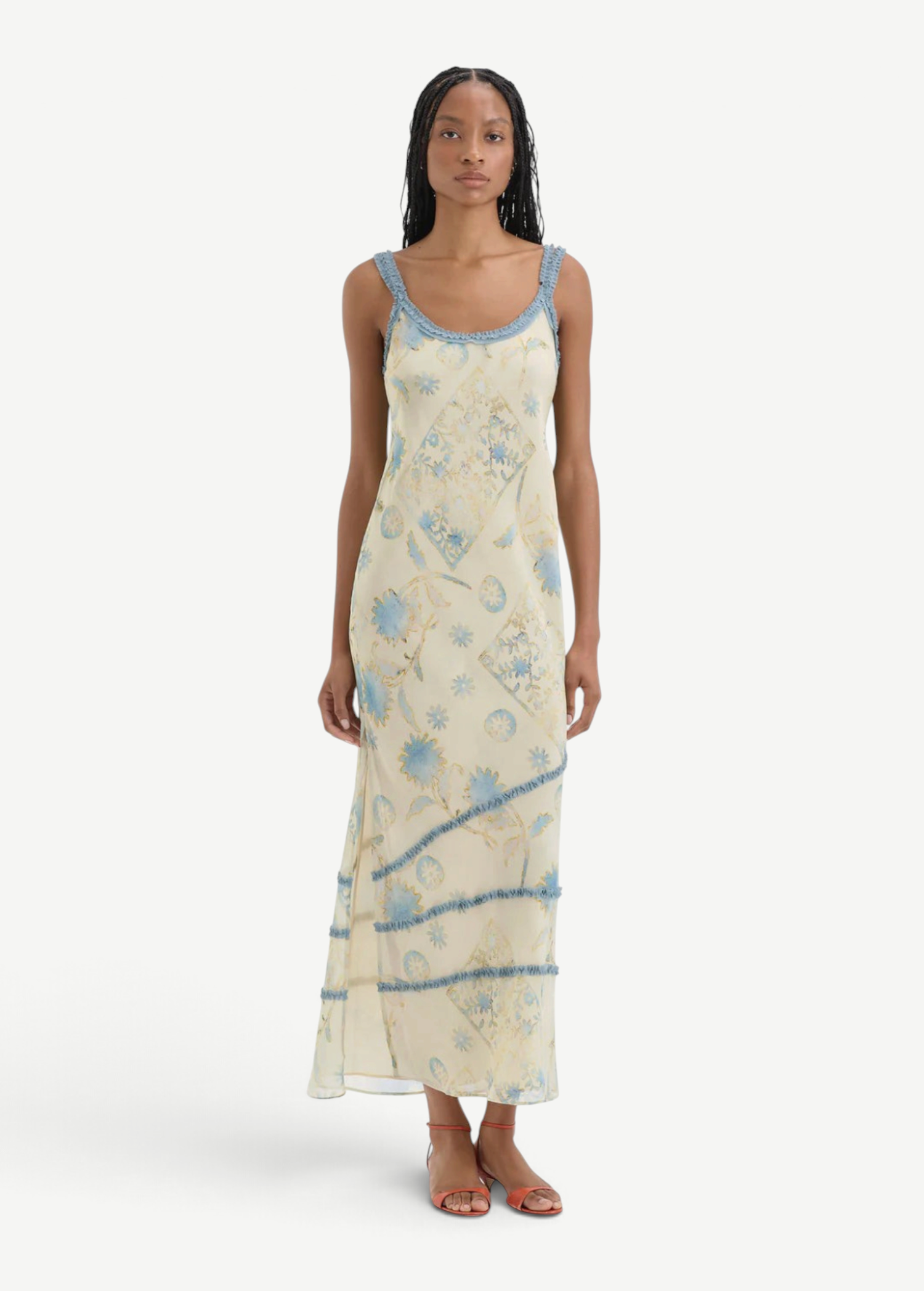 Model wearing KABE SHOP INC Cecile maxi slip dress in cream with blue vintage floral print and delicate ruffle trim.