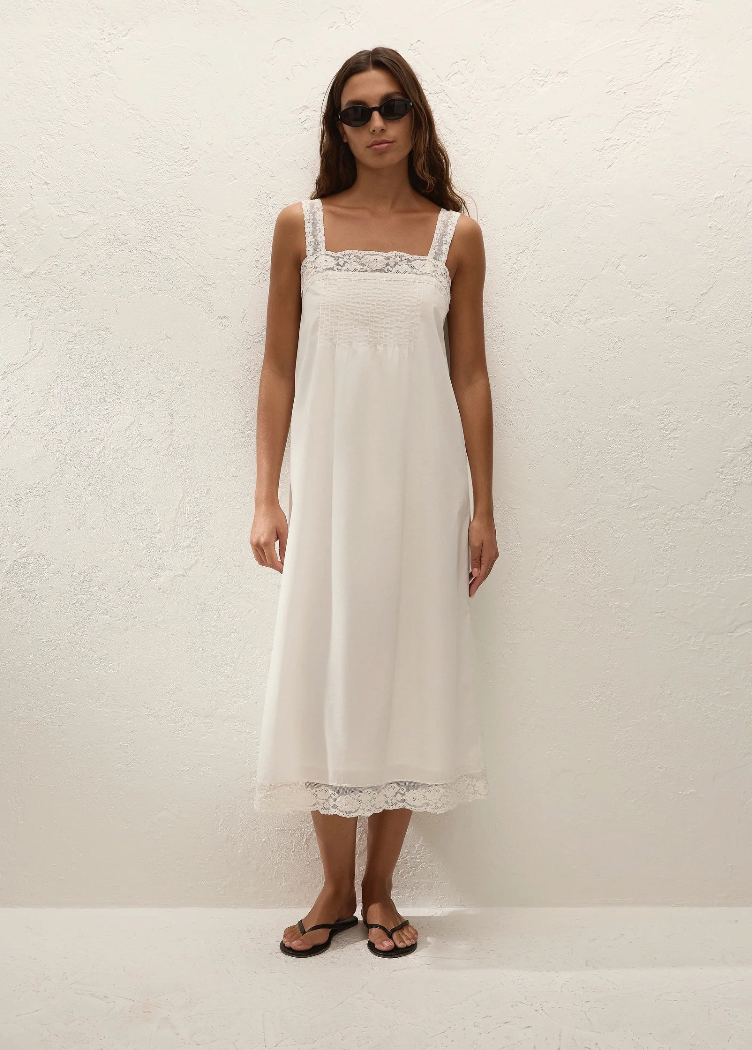 Model wearing a white KABE SHOP INC Cristina midi slip dress with delicate lace trim and square neckline
