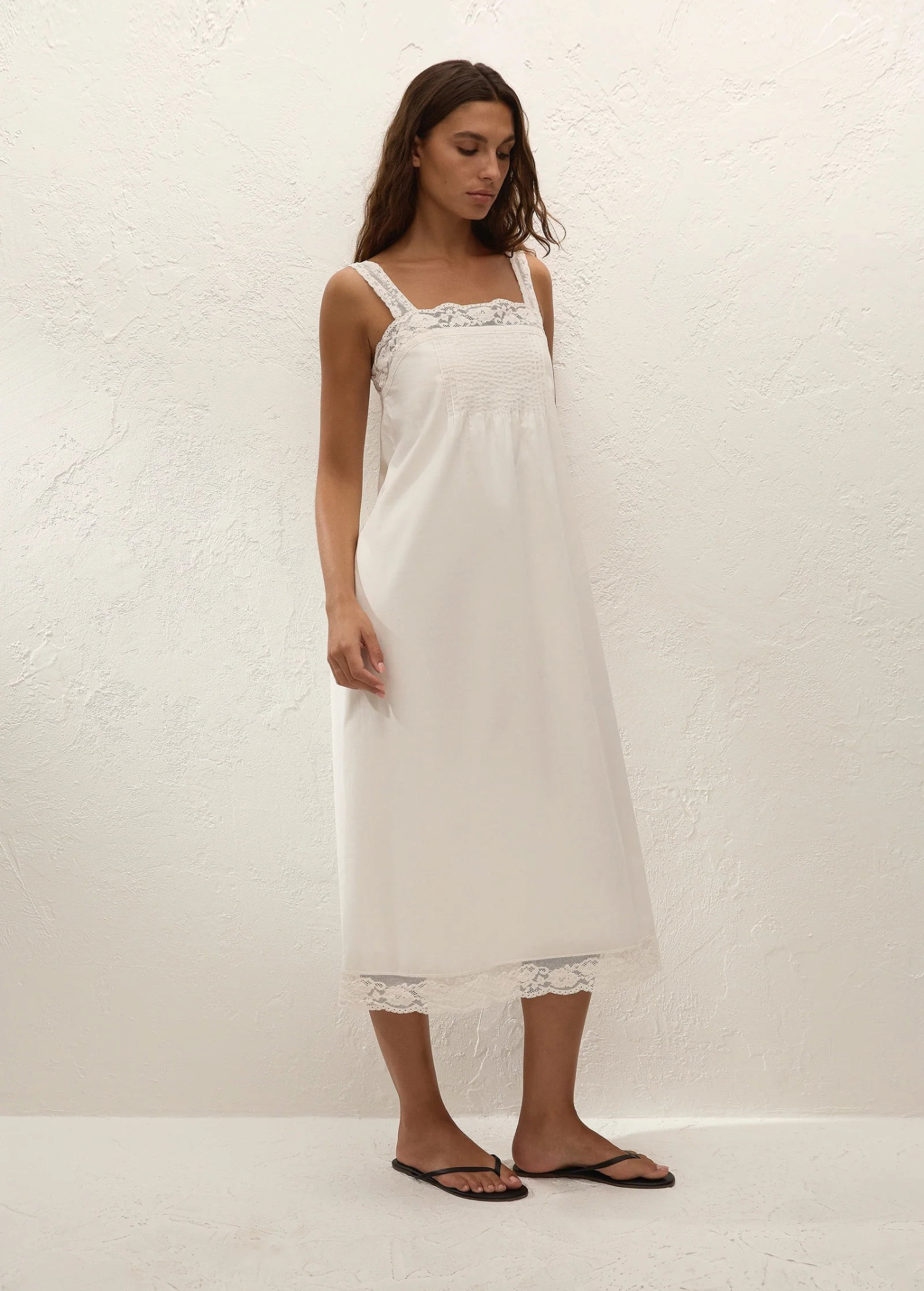 Model wearing KABE SHOP INC Cristina midi slip dress in white with delicate lace trim and vintage-inspired silhouette