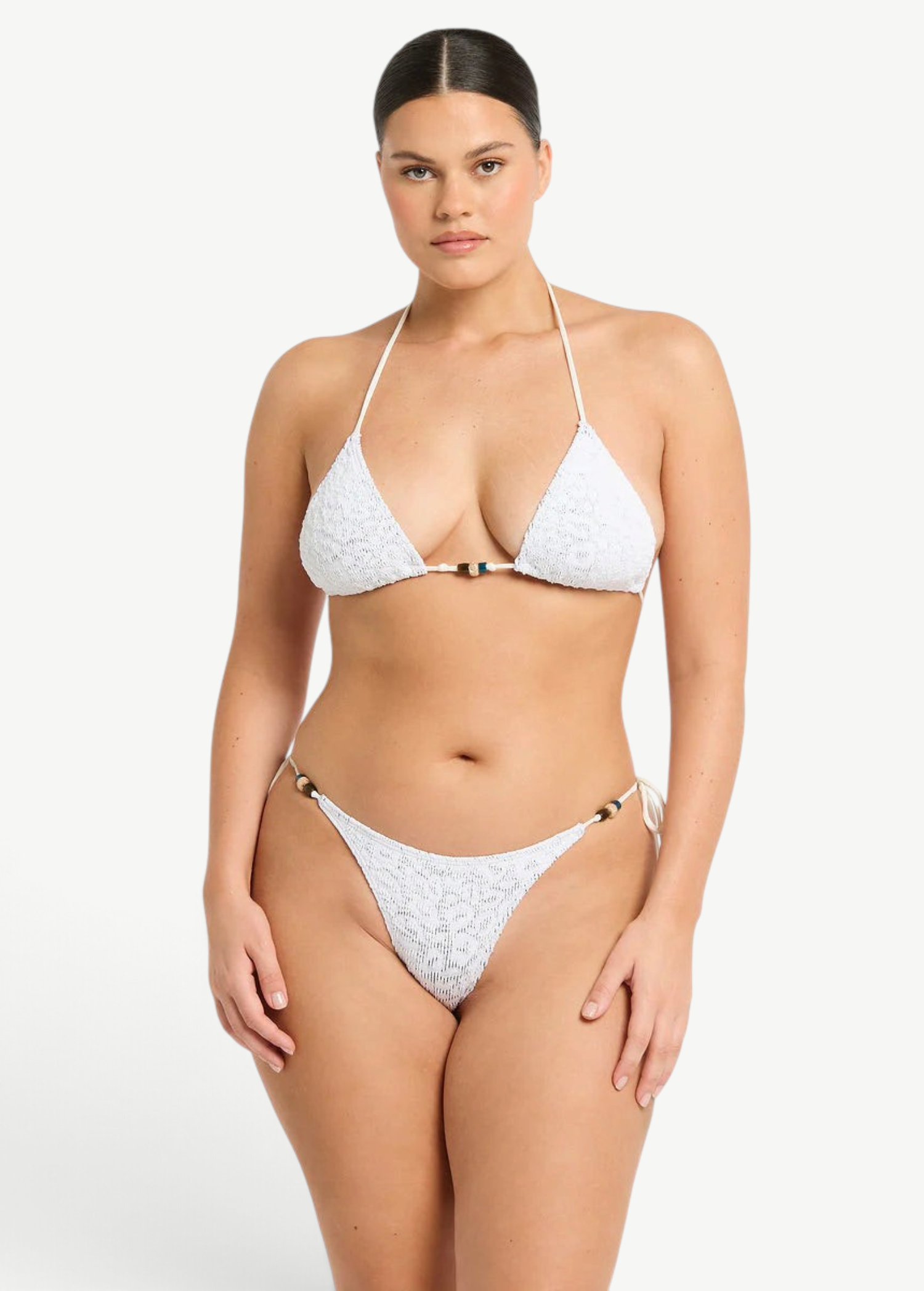 Model wearing KABE SHOP INC white textured bikini with beaded details and adjustable side ties on the Vista Brief