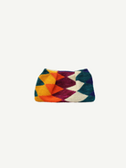 The Sisal Medium Pouch features a vibrant zigzag pattern in yellow, orange, purple, white, and teal set against a crisp white background—its colorful woven design draws inspiration from the intricate textures of natural fiber rugs.