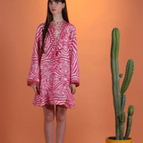 Model wearing a KABE SHOP INC Poccaa pink and white zebra print short kaftan with lace-up neckline and mirror details.