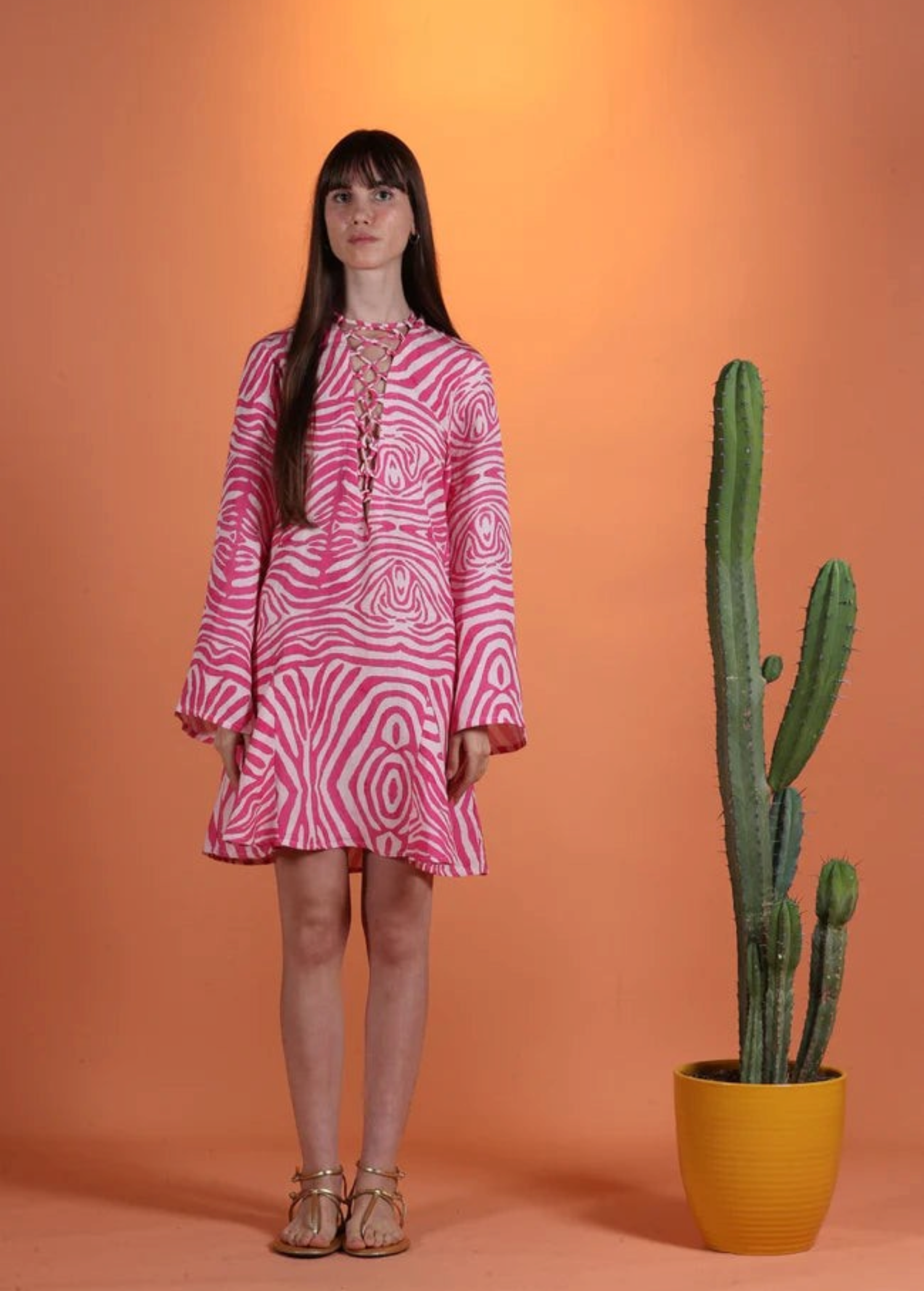 Model wearing a KABE SHOP INC Poccaa short kaftan with a pink and white zebra print and lace-up neckline