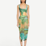 KABE SHOP INC Magdalena Pareo featuring a fluid landscape print in green and orange, worn as a wrap skirt.