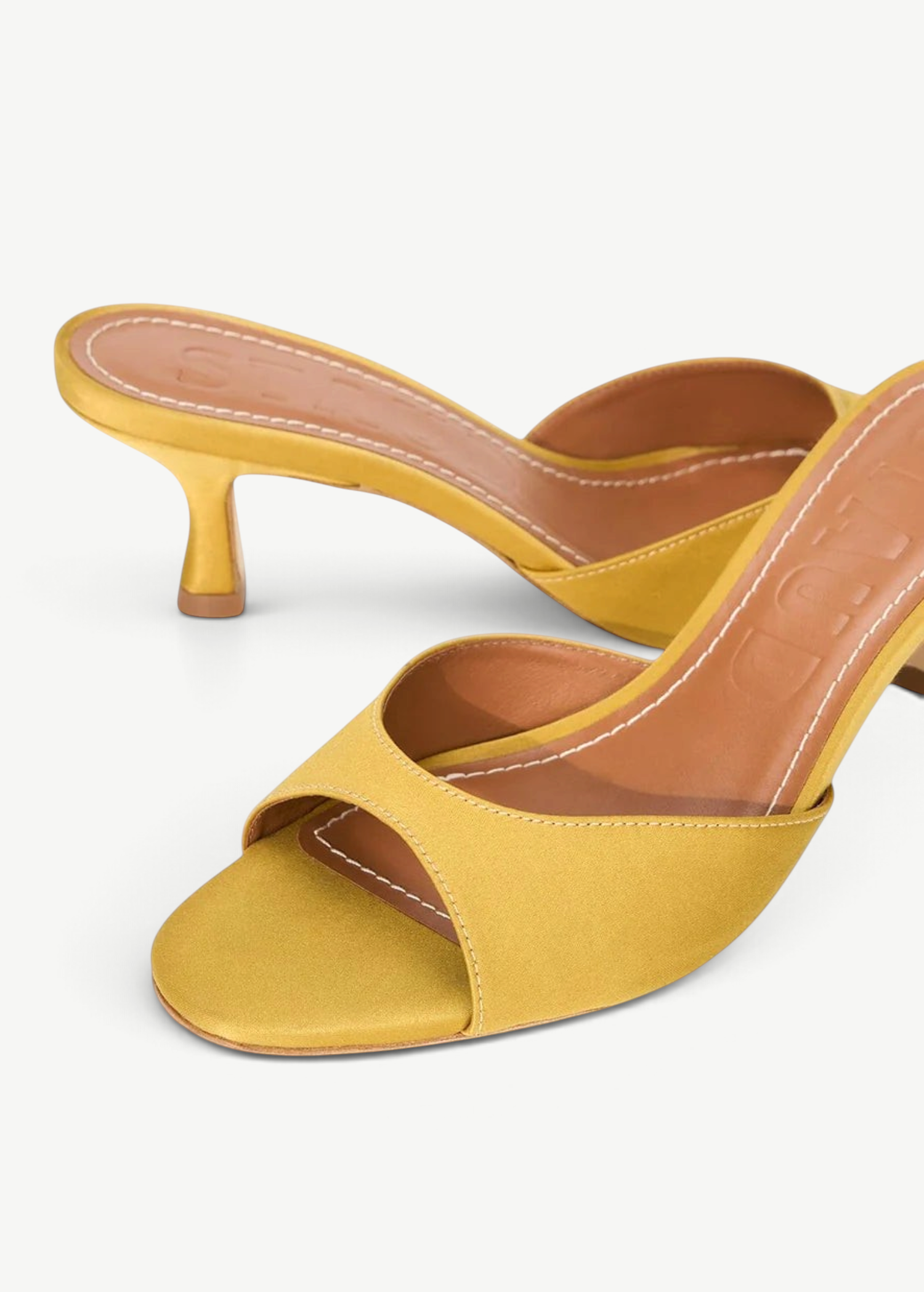 KABE SHOP INC Brigitte mule heels in mustard yellow satin with a low kitten heel and open toe design.