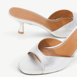 Brigitte Heel silver metallic kitten-heel mules with an open toe and tan leather footbed, featuring a refined silhouette.