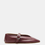 A single Stella Slipper Leather Shoe in rich rouge leather, showcasing a pointed toe, low heel, and a thin strap across the top fastened with a polished buckle, displayed against a white background.
