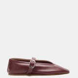 A single Stella Slipper Leather Shoe in rich rouge leather, showcasing a pointed toe, low heel, and a thin strap across the top fastened with a polished buckle, displayed against a white background.