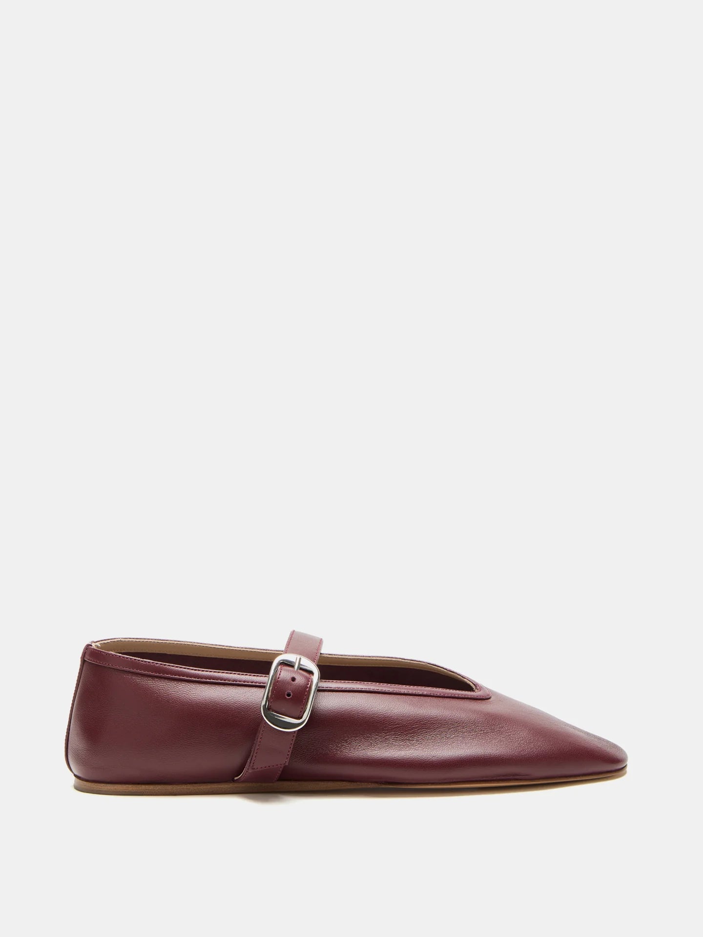A single Stella Slipper Leather Shoe in rich rouge leather, showcasing a pointed toe, low heel, and a thin strap across the top fastened with a polished buckle, displayed against a white background.