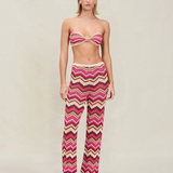 Model wearing KABE SHOP INC Cierra knit pants featuring a pink, brown, and cream chevron pattern with elastic waist.