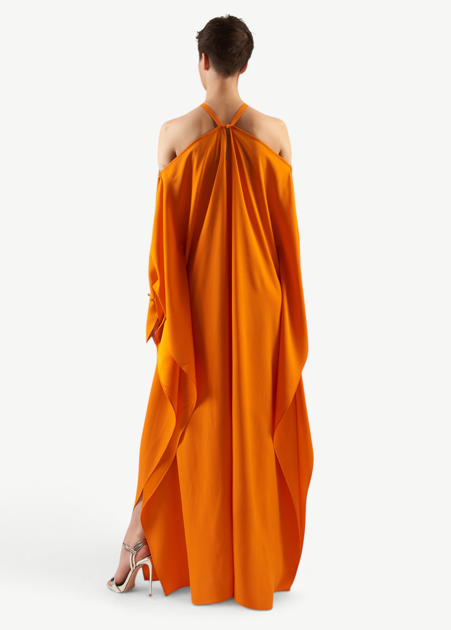 KABE SHOP INC Volturno kaftan in vibrant orange with off-shoulder halterneck, flowing sleeves, and ring details.