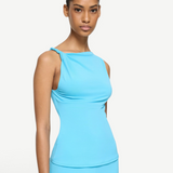 Elemental Twist Singlet in bright blue, featuring a sleeveless design with a sculptural shoulder and twisted strap detail.