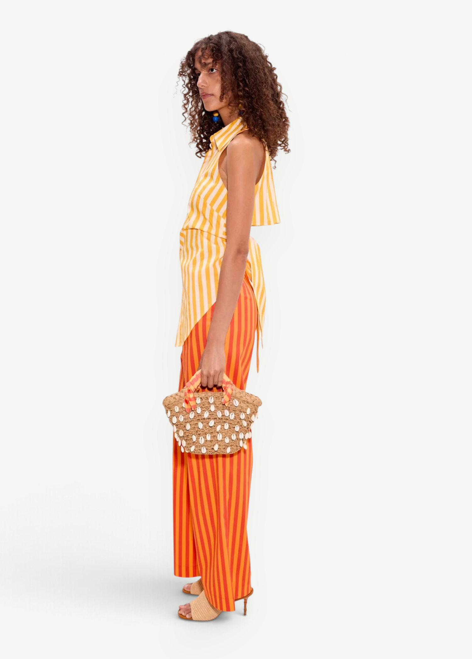 Model wearing KABE SHOP INC yellow and white striped sleeveless poplin button-up top with open-back detail.