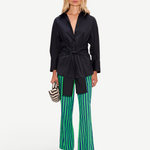 Model wearing KABE SHOP INC Pia Poplin Pant in vibrant green and blue stripes with a black button-down shirt
