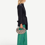 KABE SHOP INC Pia Poplin Pant in vibrant green and blue stripes, styled with a black shirt and woven crescent bag.