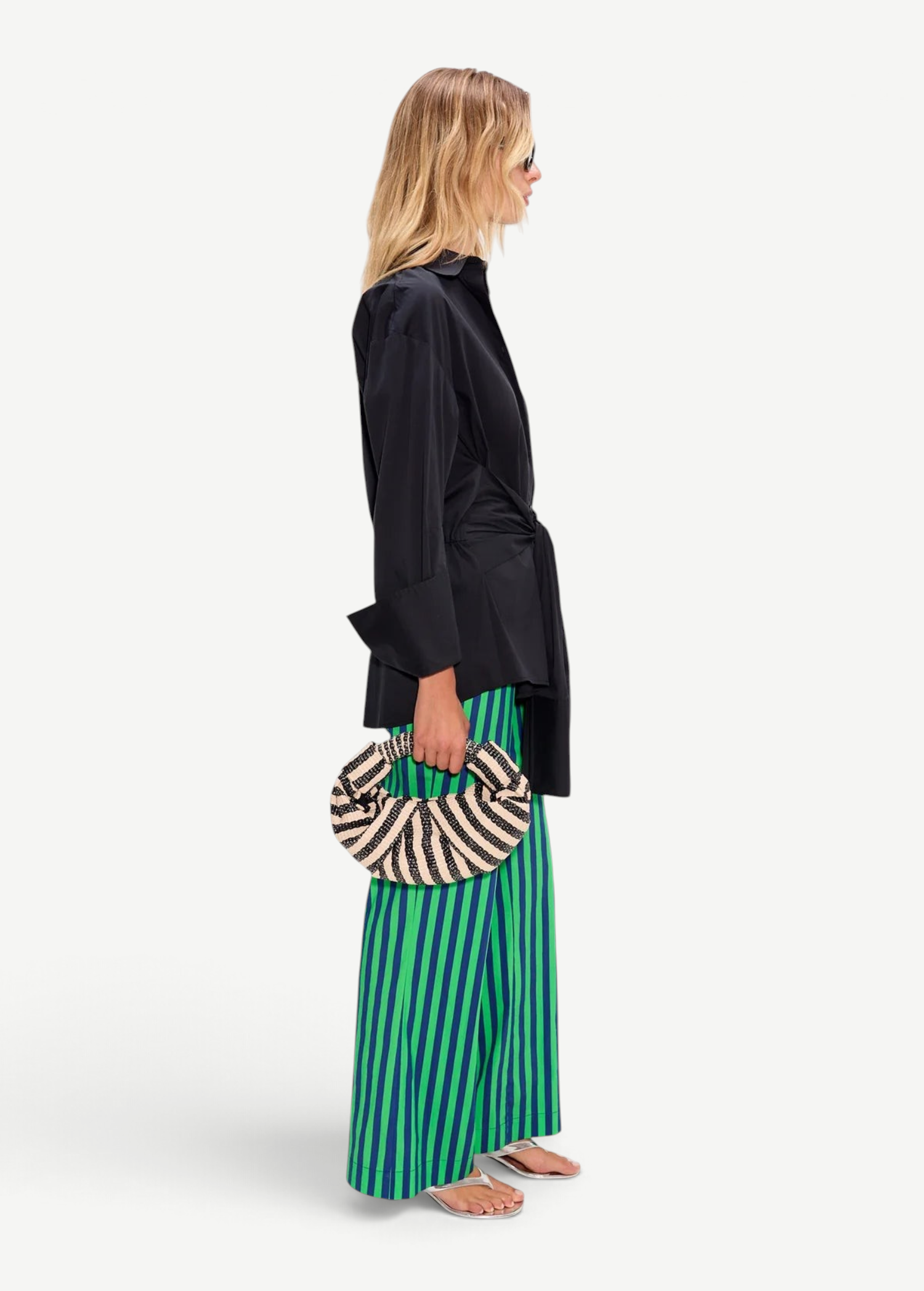 KABE SHOP INC Pia Poplin Pant in vibrant green and blue stripes, styled with a black shirt and woven crescent bag.