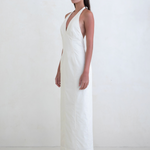 Model wearing a white KABE SHOP INC Helia halter gown with a plunging neckline and floor-length silhouette
