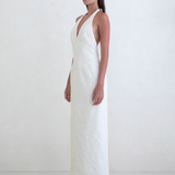 Model wearing a white KABE SHOP INC Helia halter gown with a plunging neckline and floor-length silhouette