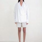 Model wearing KABE SHOP INC Leandra white convertible wrap shirt with long sleeves and relaxed fit