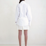 Back view of a model wearing the white KABE SHOP INC Leandra wrap shirt with a relaxed fit and long sleeves.