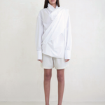 Model wearing KABE SHOP INC Leandra white convertible wrap shirt with long sleeves and relaxed fluid silhouette