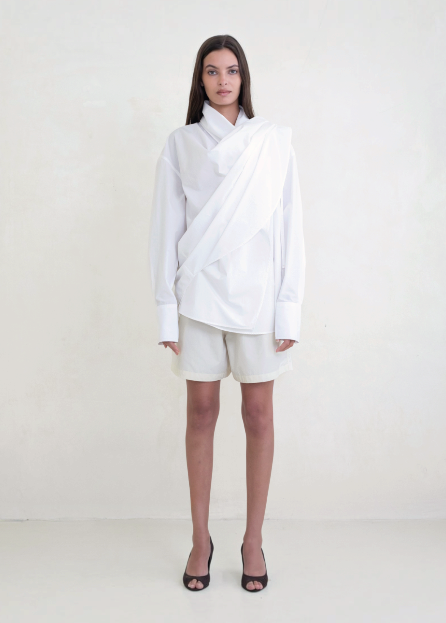 Model wearing KABE SHOP INC Leandra white convertible wrap shirt with long sleeves and relaxed fluid silhouette