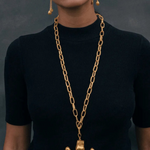 KABE SHOP INC Wanpu necklace featuring a gold anthropomorphic pendant on a chunky chain worn by a model