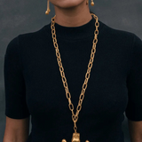 KABE SHOP INC Wanpu necklace featuring a gold anthropomorphic pendant on a chunky chain worn by a model