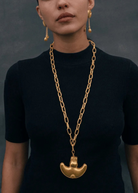 KABE SHOP INC Wanpu necklace featuring a gold anthropomorphic pendant on a chunky chain worn by a model