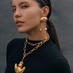 KABE SHOP INC Wanpu necklace with gold anthropomorphic pendant on a model wearing a black top