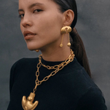 KABE SHOP INC Wanpu necklace with gold anthropomorphic pendant on a model wearing a black top