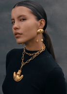 KABE SHOP INC Wanpu necklace with gold anthropomorphic pendant on a model wearing a black top