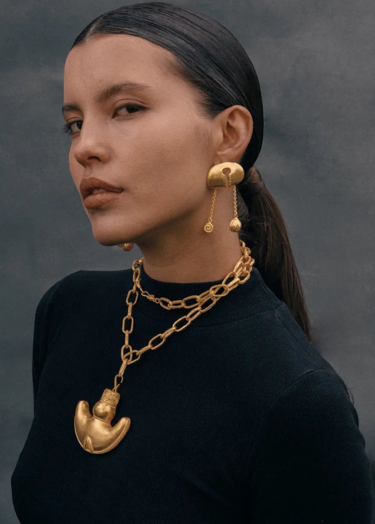 KABE SHOP INC Wanpu necklace with gold anthropomorphic pendant on a model wearing a black top