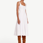 Model wearing a KABE SHOP INC white Wells midi dress with a square neckline and full skirt, paired with brown boots.