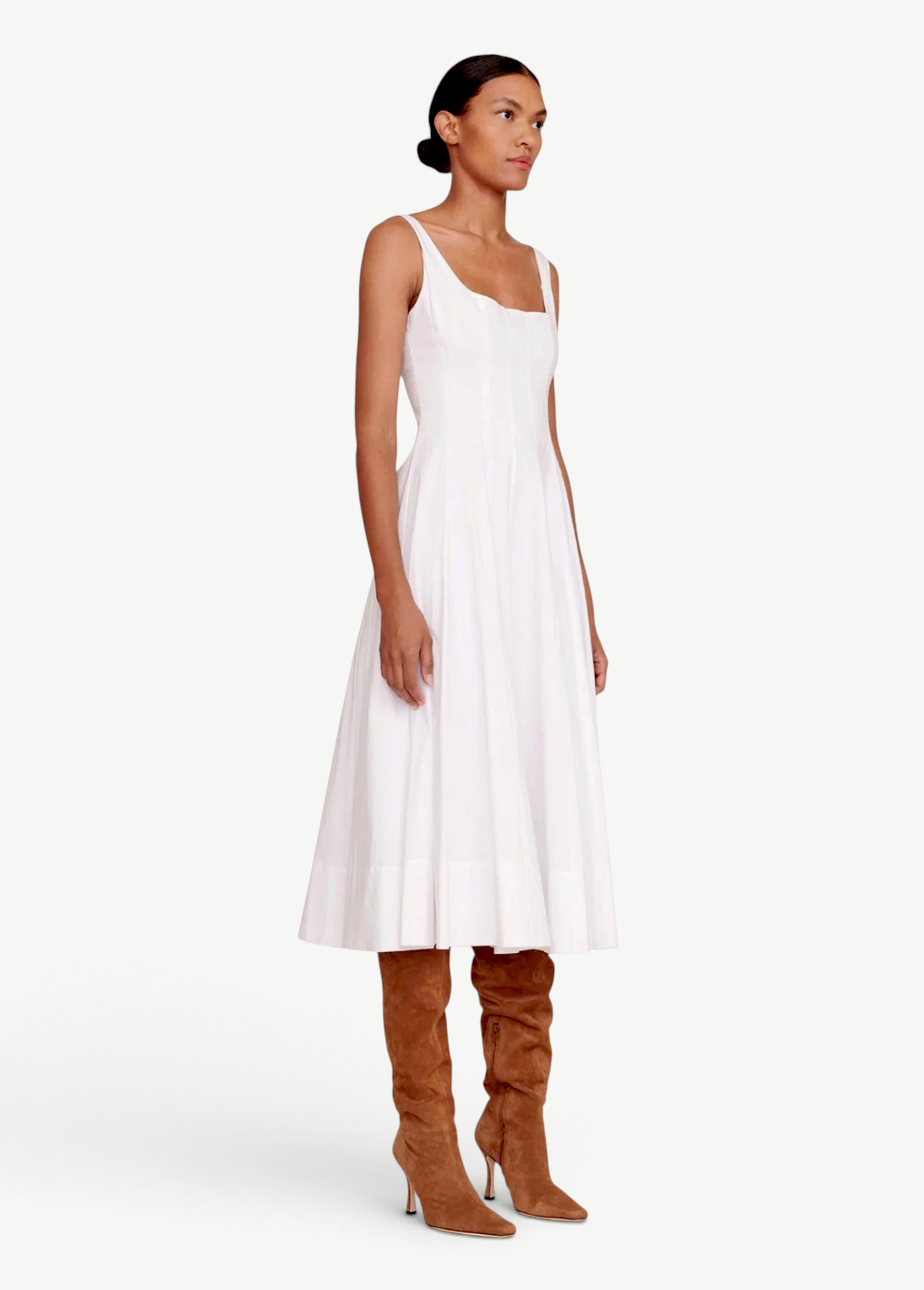 Model wearing a KABE SHOP INC white Wells midi dress with a square neckline and full skirt, paired with brown boots.