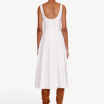 Back view of KABE SHOP INC Wells white midi dress with a scoop back and flared skirt paired with brown suede boots.